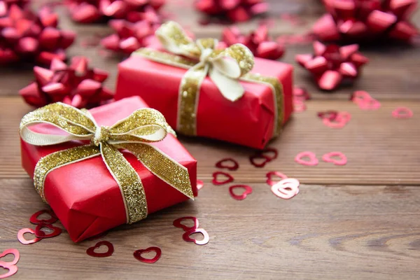 Piros ajándék doboz íjakkal, fa háttérrel. Másold a helyet. Valentin-nap, Születésnap, Karácsony. — Stock Fotó