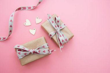 Kravat kağıdına sarılı hediye kutusu ve pembe arka planda fiyonk. Sevgililer Günü, Doğum günü, Parti konsepti.