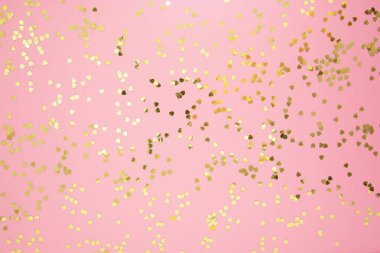 Pembe arka planda soyut desenli, altın kalp şeklinde parıltılı. Sevgililer günü, aşk, doğum günü, parti konsepti. Kopyalama alanı olan düz.