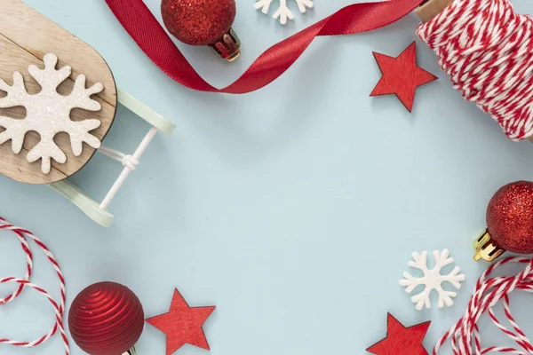 Fondo de Navidad, decoraciones de invierno: lazo de cinta, trineo, adornos, copos de nieve sobre fondo azul, con espacio para copiar — Foto de Stock