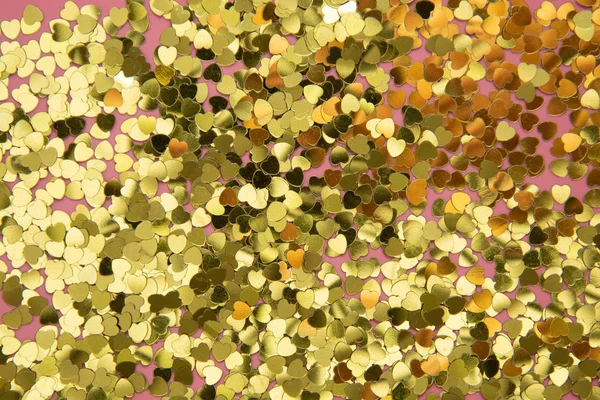 Backgraund texturizado abstrato, forma de coração dourado glitter sobre fundo rosa. Dia dos Namorados, amor, aniversário, conceito de festa. Flat lay com espaço de cópia . — Fotografia de Stock