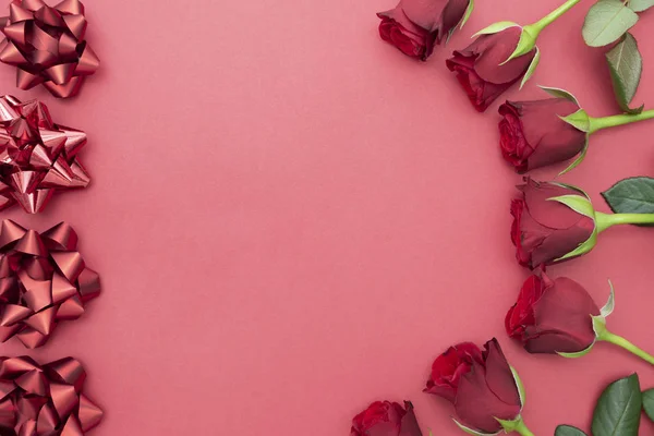 Röda rosor gåva, band bågar över rosa bakgrund platt låg. Alla hjärtans dag, födelsedag abstrakt bakgrund med kopia utrymme. — Stockfoto