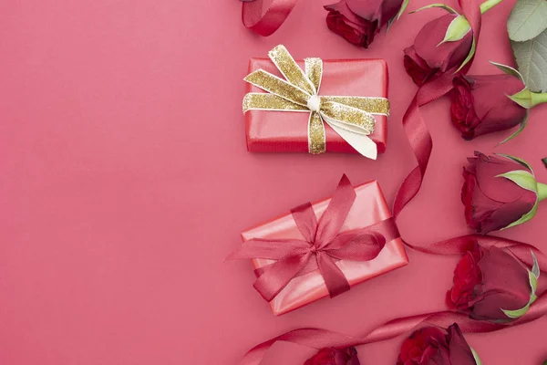День святого Валентина, красные розы и подарочная коробка с лентой, на красном фоне лежа, день рождения абстрактный фон с копировальным пространством . — стоковое фото