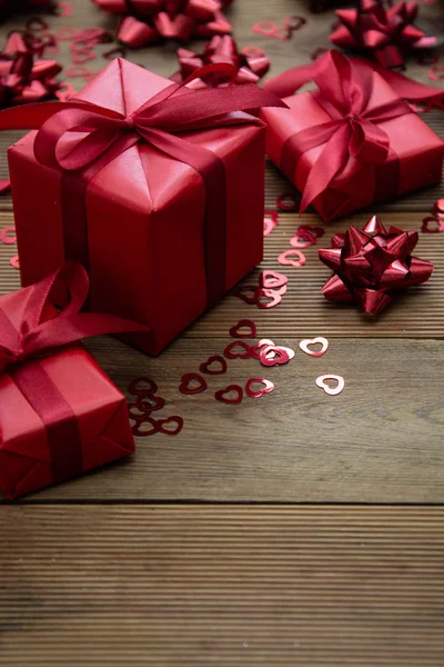 Röd presentask med rosetter, på trä bakgrund. Uppfattat utrymme. Alla hjärtans dag, födelsedag, jul. — Stockfoto