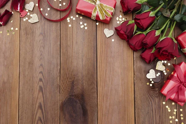 Rosas rojas y caja de regalo con cinta, sobre fondo de madera planas. Día de San Valentín, Fondo abstracto de cumpleaños con espacio para copiar . — Foto de Stock