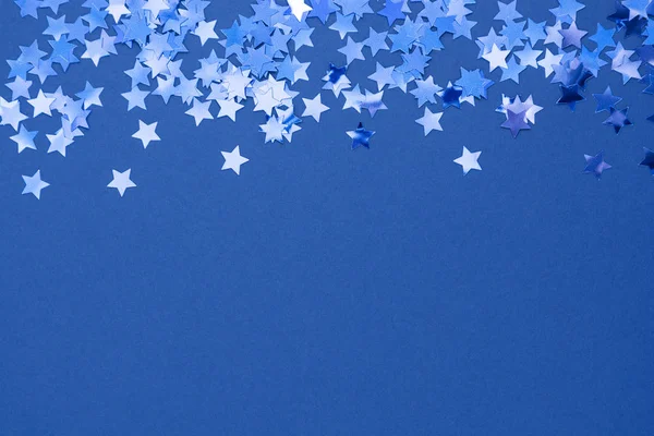 Kék elvont karácsonyi háttér vagy textúra csillagok konfetti kék háttérrel. A szöveg helye. — Stock Fotó