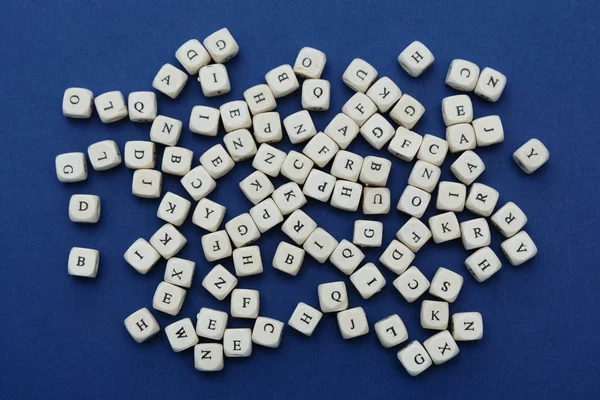 Wooden letter blocks over blue background, top view. — Stock Photo, Image