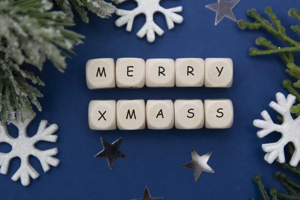 Palabra Feliz Navidad escrita en cubos de madera sobre fondo azul con decoración de invierno, fondo de Navidad . —  Fotos de Stock