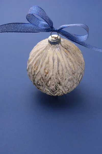 Mavi kurdeleli bir Noel mücevheri, mavi arka planda izole edilmiş. Klasik mavi soyut arkaplan. Boşluğu kopyala. — Stok fotoğraf