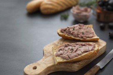 Et tavuğu ya da domuz ciğeri ezmeli sandviç. Toptan ekmek dilimleri, koyu arkaplan. Boşluğu kopyala.