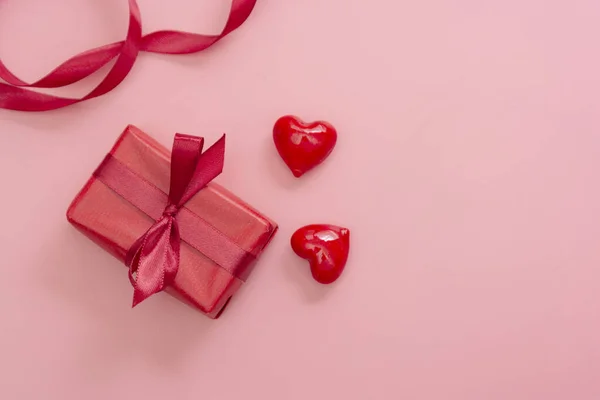 Piros ajándék doboz rózsaszín háttér elszigetelt. Valentin nap gúnyolódik a fénymásolás hely. — Stock Fotó