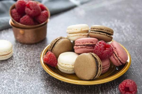 Colorful macaronsin a plate on dark background. Healthy cake dessert made from almond flour. Raspberry macaroons cookies. — Stock Photo, Image