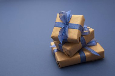Noel ya da doğum günü hediyeleri. Mavi arkaplana paketlenmiş el işi kağıt, kopyalama alanı ile düz uzanır.
