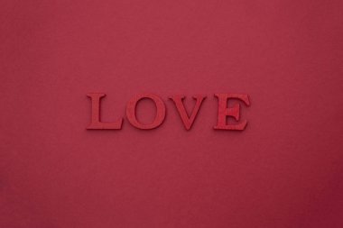 Aşk mektupları, kırmızı arka planda 3 boyutlu ahşap harfler. Yaratıcı Sevgililer Günü modeli. Kelimesi kelimesine aşk..