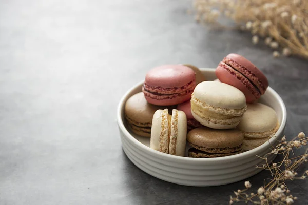 French macaron cakes in a plate close up. Cream, brown, pink, macarons with copy space. — Stock Photo, Image