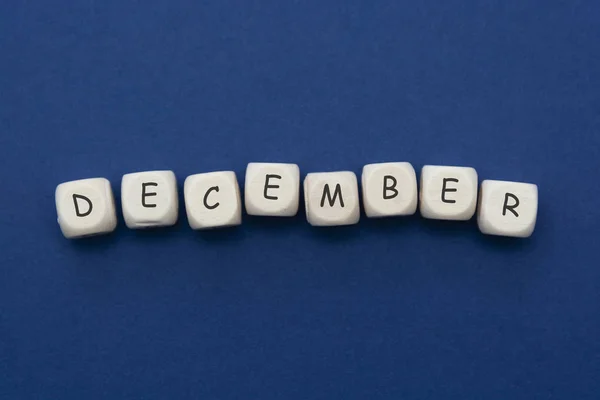 December lettering. Wooden blocks with december word over clasic blue blackground. Copy space. — Stock Photo, Image