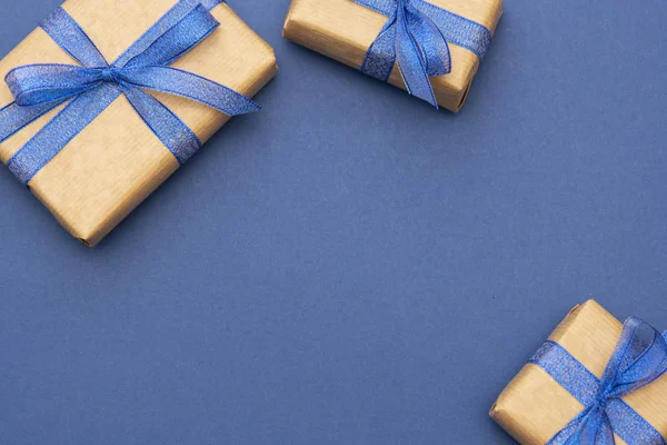 Cadeaux de Noël ou d'anniversaire cadre ou frontière. Craft papier enveloppé boîtes-cadeaux sur fond bleu, plat laïc. Espace de copie . — Photo