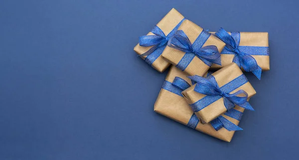 Vánoční prapor. Řemeslný papír zabalený v dárkových krabicích na modrém pozadí, plochý ležel. Kopírovat prostor. — Stock fotografie