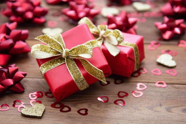 Piros ajándék doboz íjakkal, fa háttérrel. Másold a helyet. Valentin-nap, Születésnap, Karácsony. — Stock Fotó