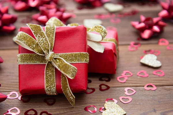 Röd presentask med rosetter, på trä bakgrund. Uppfattat utrymme. Alla hjärtans dag, födelsedag, jul. — Stockfoto