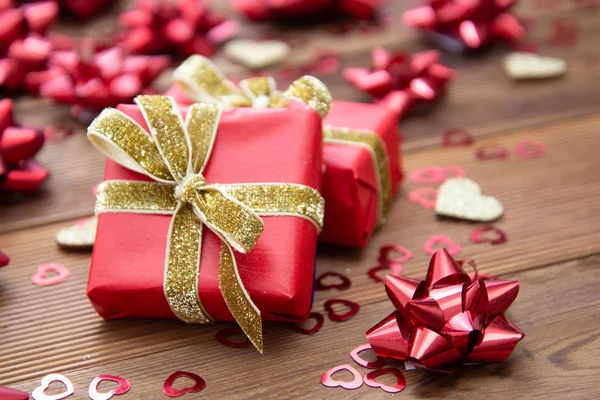 Caja de regalo roja con lazos, sobre fondo de madera. Copiar espacio. San Valentín, Cumpleaños, Navidad . Imagen De Stock
