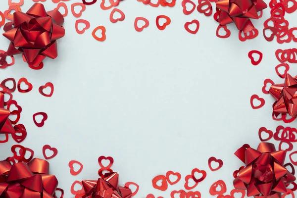 Красные конфетти в форме сердца и красные ленточки, День святого Валентина фон макет — стоковое фото