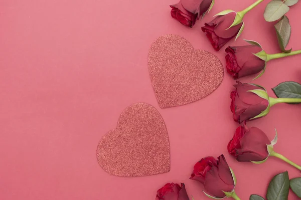 Kırmızı güller ve parlak kalpler kırmızı arka planda yatıyordu. Sevgililer Günü, kopyalama alanı olan soyut arkaplan. — Stok fotoğraf