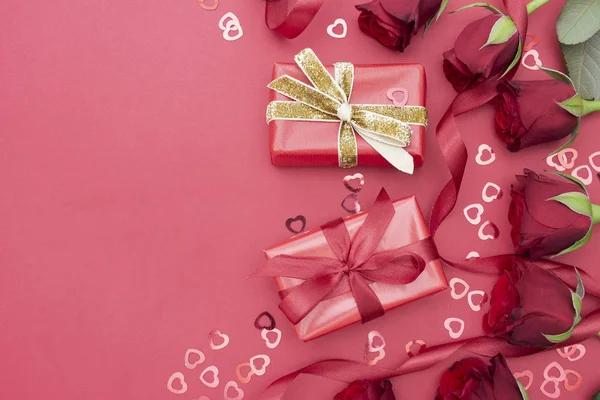 Valentines Day, red roses and gift box with ribbon, over red background flat lay, birthday abstract background with copy space. — ストック写真