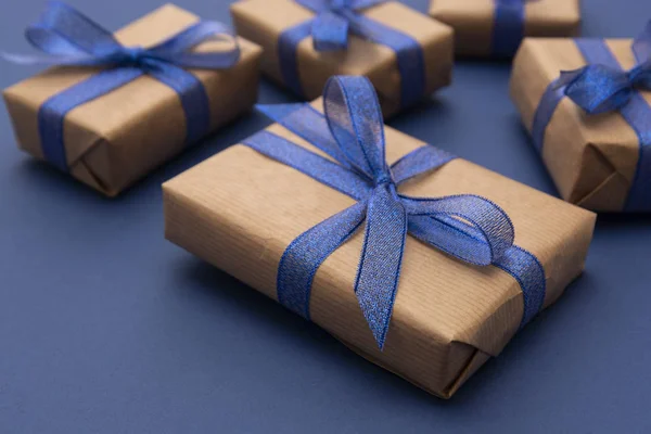 Stäng presentlådor, presenter. Hantverkspapper inslagna presentförpackningar på blå bakgrund. — Stockfoto