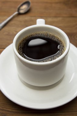 Kahve fincanı ahşap masada izole edilmiş. Üst manzara, düz kahve içeceği ve fotokopi alanı..