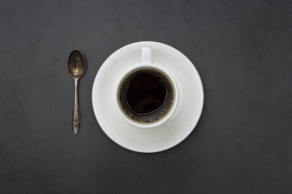 Café. Taça branca de café vista superior colher e placa no fundo escuro — Fotografia de Stock