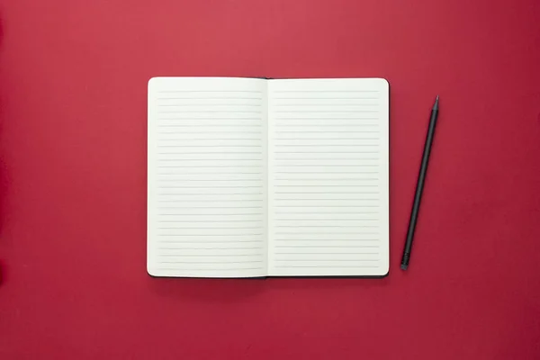 Offenes Notizbuch isoliert auf rotem Hintergrund, Kopierraum für Text. — Stockfoto