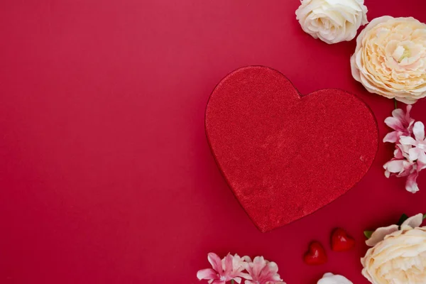 Caja de regalo en forma de corazón con flores sobre fondo rojo. Día de San Valentín burla con espacio para copias . — Foto de Stock