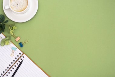 Not defteri ve kahve fincanı olan bir ofis masası. Masa üstü, kopyalama alanı olan çalışma alanı. Yaratıcı düz yatak.