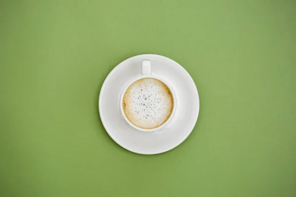 Top vista café latte quente na xícara branca. Isolado em fundo verde. Espaço de cópia . — Fotografia de Stock