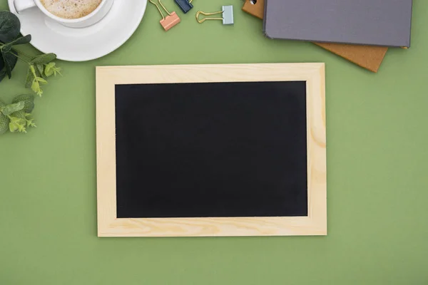 Vista superior del marco de pizarra con taza de café, sobre fondo verde. Prepárate para el diseño. Copiar espacio . —  Fotos de Stock