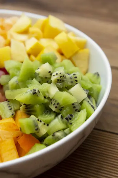 Salad buah segar - mangga, jeruk, buah kiwi, plum dan kesemek. Latar belakang kayu, berbaring datar, atas melihat makanan sehat. Campuran Smoothie . — Stok Foto
