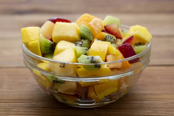 Mangkuk gelas salad buah-buahan segar - mangga, sitrus, buah kiwi, plum dan kesemek. Makanan sehat. Campuran Smoothie . — Stok Foto