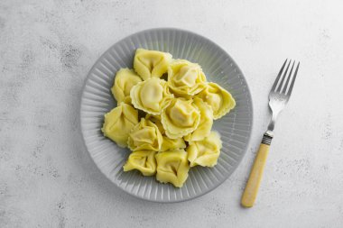 Bir tabakta pişmiş tortellini manzarası, izole makarna tabağı..