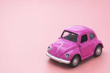 Corby, İngiltere 7 Şubat 2020. Pembe arka planda minyatür pembe oyuncak araba. Minimum konsept. Metin için alanı kopyala.