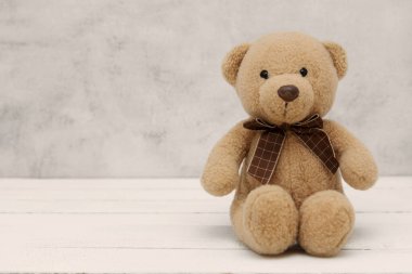 Gri arka planda yumuşak oyuncak, izole edilmiş. Eğitim, ebeveynlik ve çocukluk bebek konsepti. Metin için alanı kopyala.