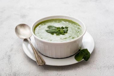 Beyaz kasede kremalı yeşil ıspanak çorbası, ilkbahar sağlıklı yeşil kremalı çorba. Detoks, diyet ya da temiz yiyecekler