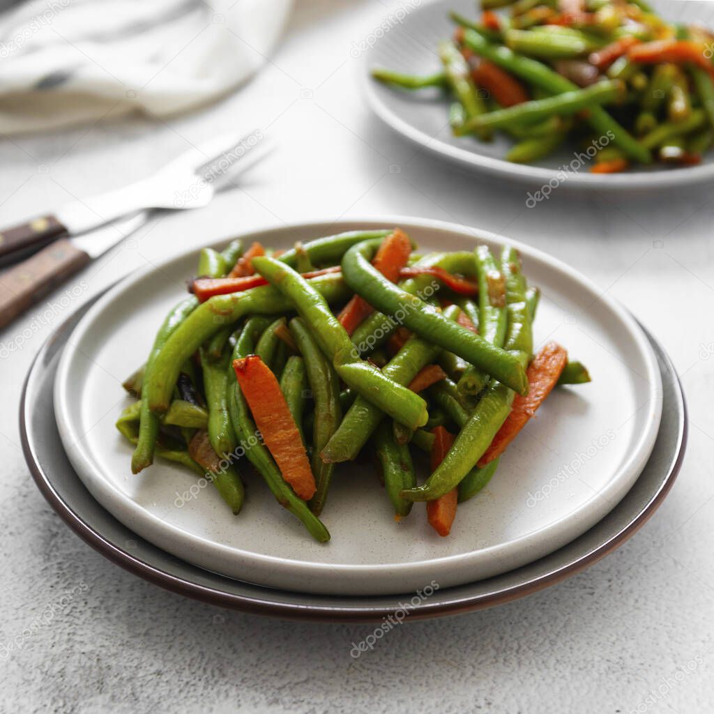 Vegetarian food. Cooked green string beans and carrots. Healthy salad of green beans and carrots closeup