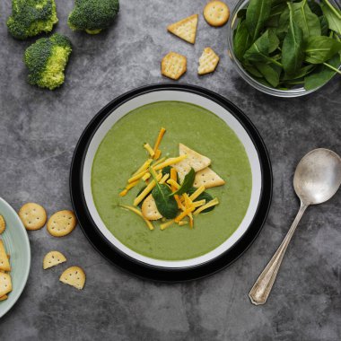 Kraker ve peynirli yeşil kremalı sebze çorbası. Sağlıklı ıspanak, brokoli vejetaryen detoks yemeği. Kare resim.