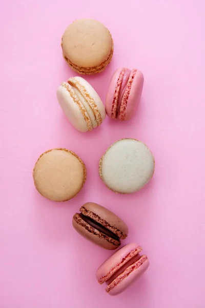 Colorful pink background with french macaroons cookies, copy space. Feminine or beauty background. — Stock Photo, Image