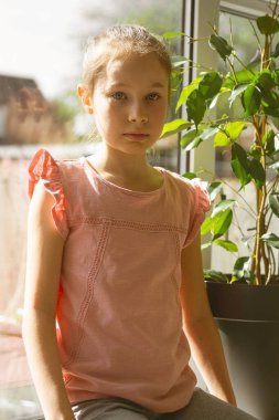 Pencereye bakan küçük bir kız. Küçük kız portresi, eğitim.