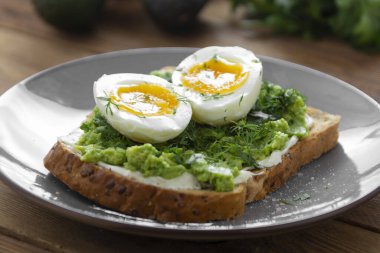 Haşlanmış yumurtalı avokado sağlıklı tost. Kare kepekli ekmek tostu. Üst görünüm.