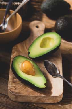 Ahşap masada avokado, izole. Sağlıklı yiyecekler. Üst görünüm.