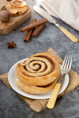 Cinnamon roll bun close up. Cinnamon swirl pastry for breakfast. clipart
