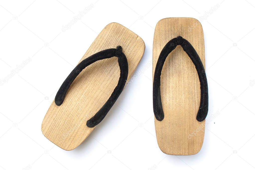 Old wooden Japanese sandal isolated on white background. It is a form of traditional Japanese footwear that resemble both clogs and flip-flops.